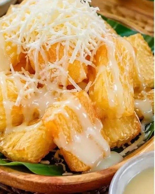 Singkong goreng dengan topping susu kental manis dan keju